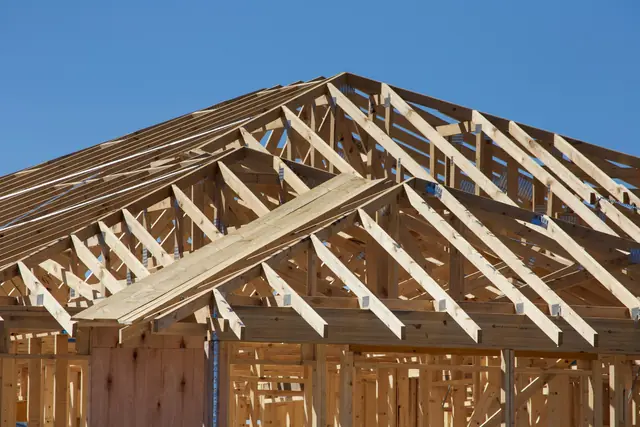 Wood framing of a new house against a blue sky