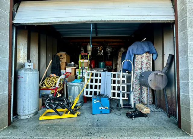 A garage packed with tools, boxes and clutter