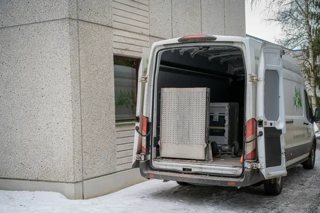 A moving van with its back doors open and furniture inside