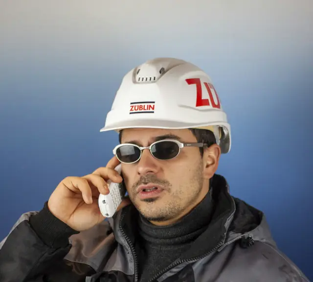A contractor in a hard hat on a phone call