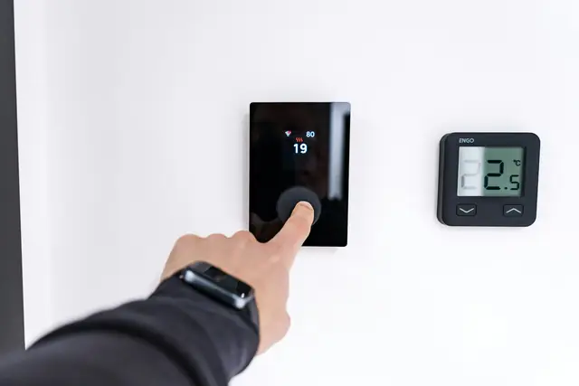 A wall-mounted smart thermostat in a home