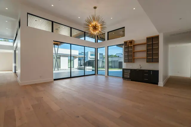 A bright, empty room with new wide-plank wood flooring